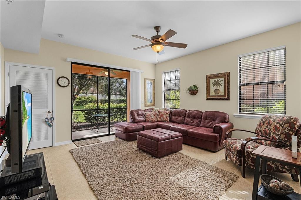 Tiled living room with plenty of natural light and ceiling fan