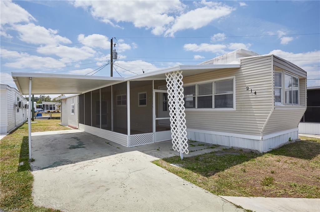 Manufactured / mobile home featuring driveway, a sunroom, and an attached carport