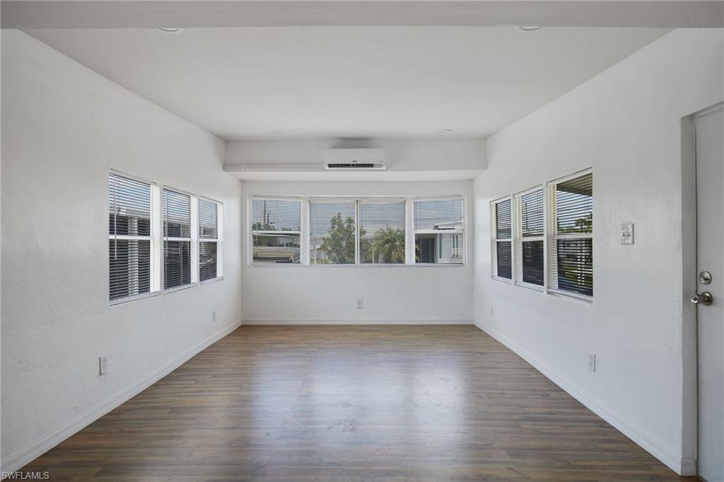 Unfurnished room with baseboards, a wall mounted AC