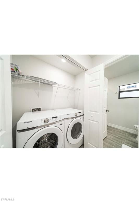 Laundry area featuring light wood-type flooring and washing machine and dryer