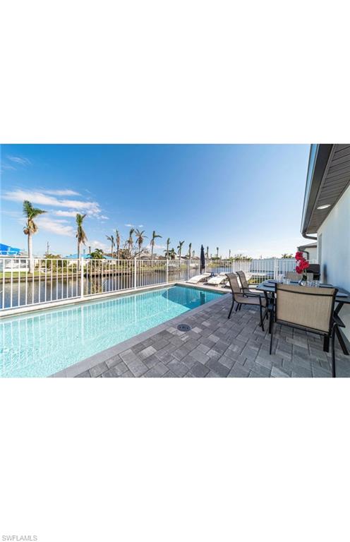 View of swimming pool with a patio area and a water view