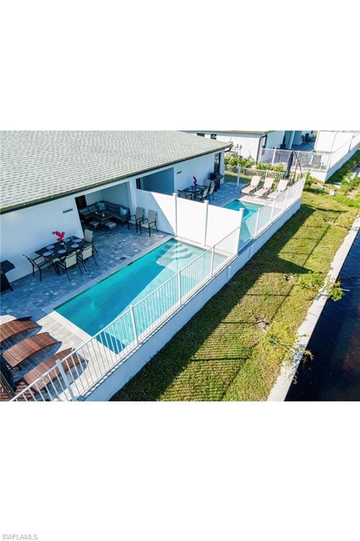 View of pool with a patio area and a lawn