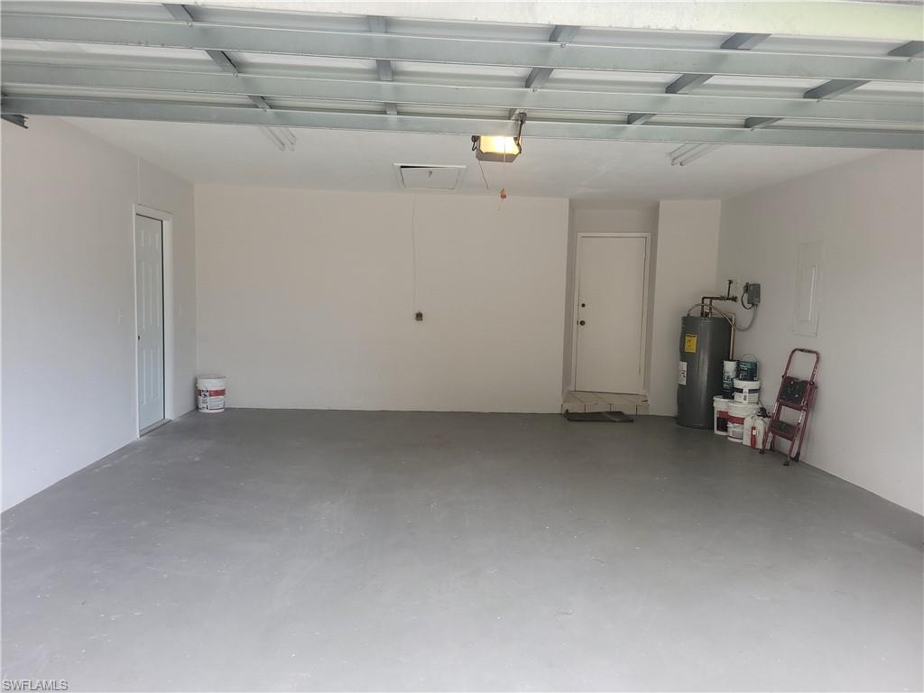 Garage featuring a garage door opener and water heater