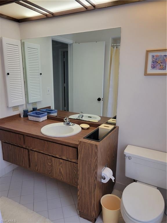 Bathroom with vanity, tile patterned floors, and toilet