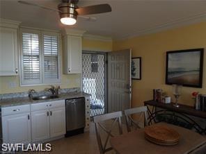 Kitchen with ceiling fan, white cabinets, sink, dishwasher, and crown molding