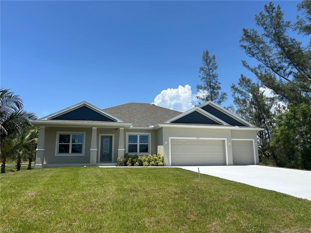 View of front facade with stucco siding, a garage, a front lawn, and driveway