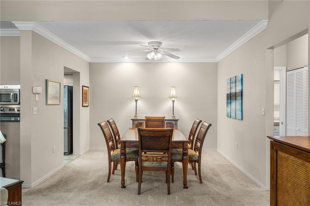 Dining space featuring crown molding, light carpet, and ceiling fan