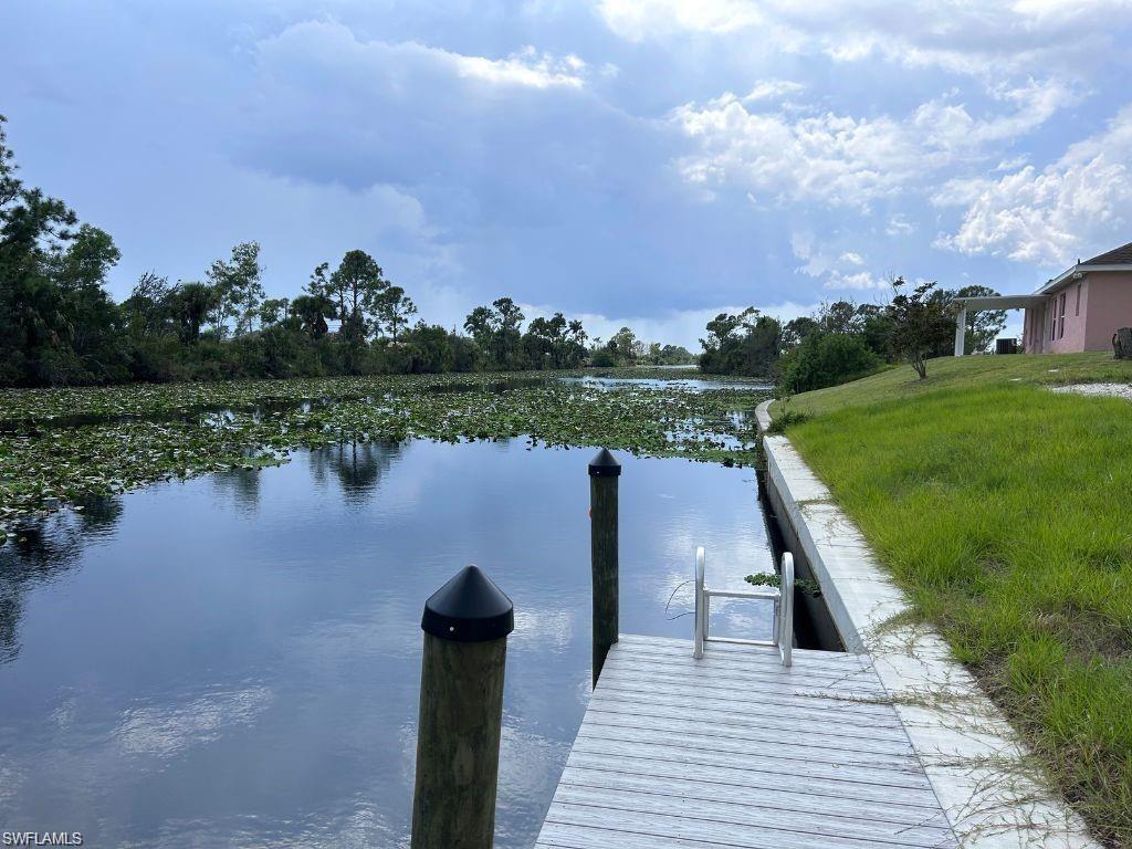 Dock area featuring a water view and a yard