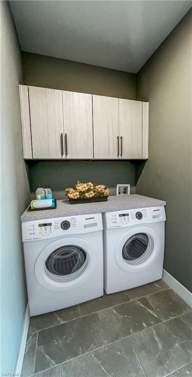 Washroom featuring cabinets and washer and dryer
