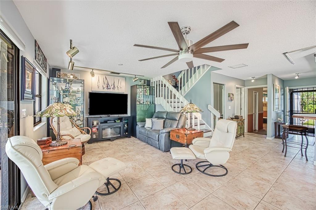 Living room with modern ceiling fan.  Flooded with natural lighting.