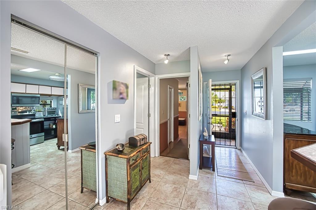 Entryway and light tile patterned flooring. From entrance, on right is the garage/bonus room and half-bath.