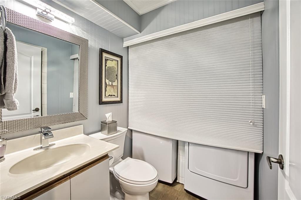 First floor full bath with shower with wood-like style floors and washer/dryer area
