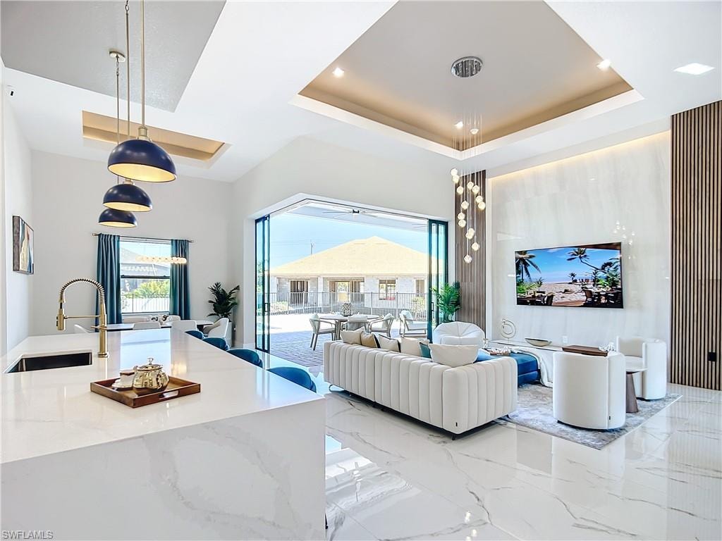 Living room featuring a tray ceiling and sink