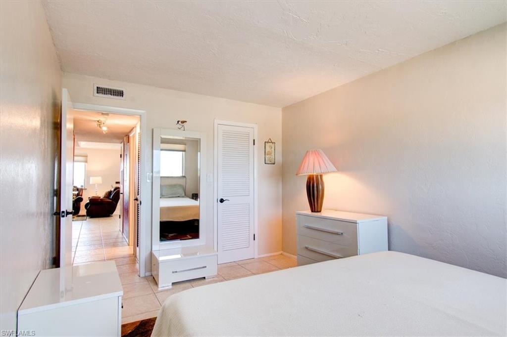 Tiled bedroom featuring a closet