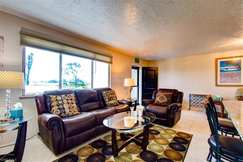 Living room featuring a textured ceiling and light tile patterned floors