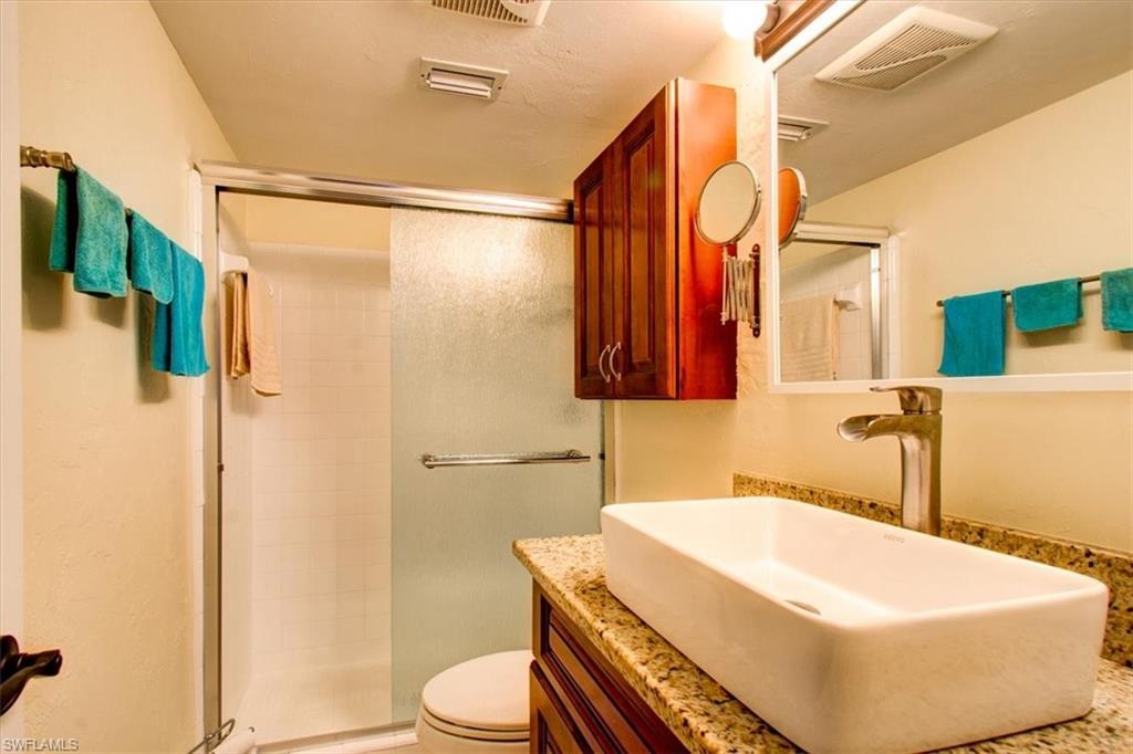 Bathroom with vanity, toilet, and an enclosed shower