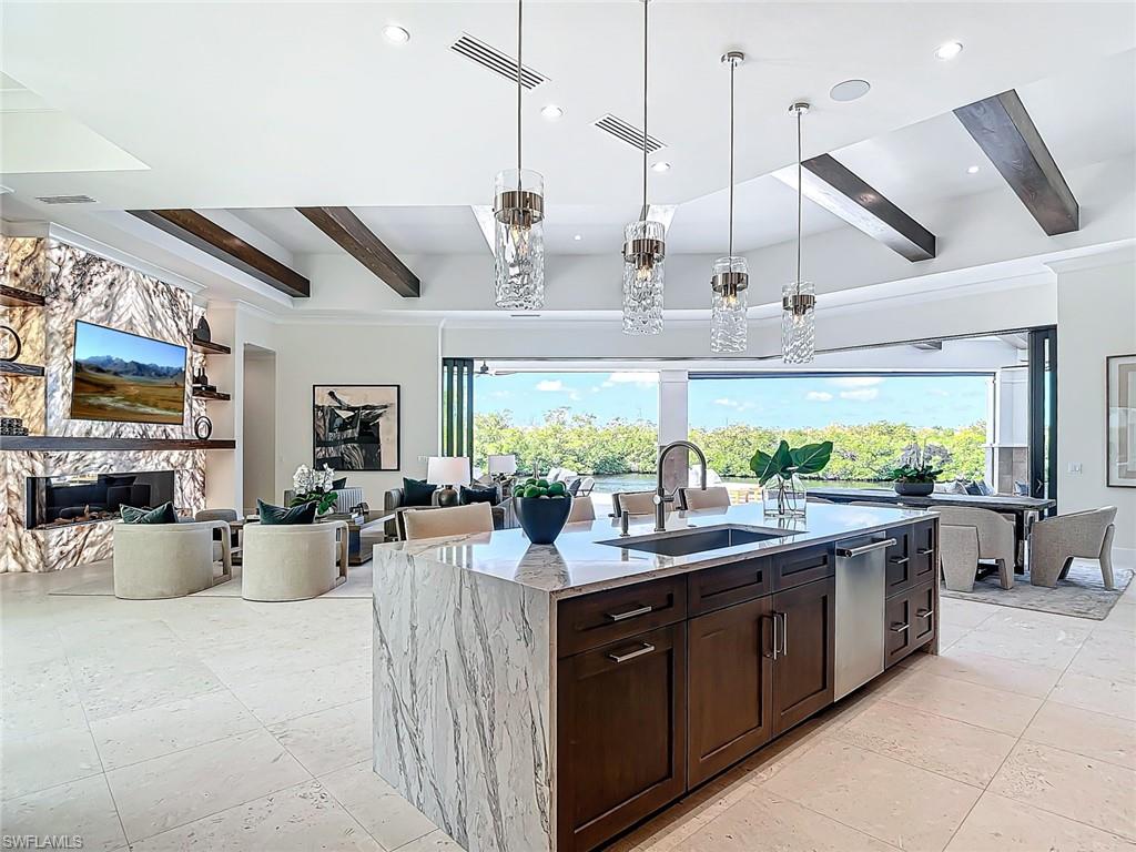 The gourmet kitchen with cabinet lighting is equipped with Monogram Smart appliances.