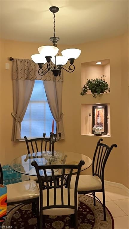 Dining area featuring light tile patterned floors and an inviting chandelier