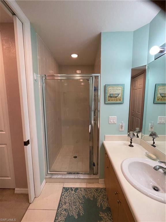 Master Bathroom featuring vanity, tile patterned flooring, and a shower with door