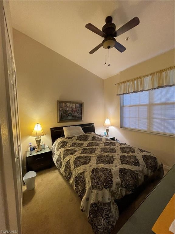 Carpeted bedroom with ceiling fan and vaulted ceiling