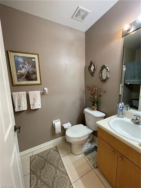 Bathroom featuring vanity, toilet, and tile patterned flooring