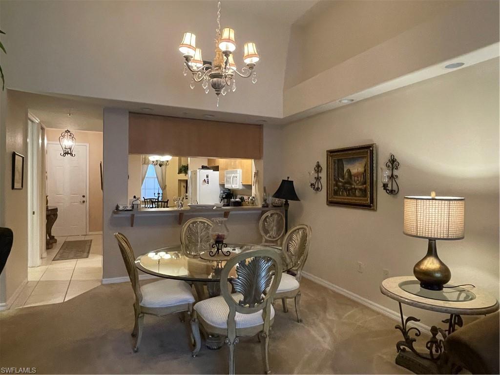 Dining space with a chandelier and light carpet