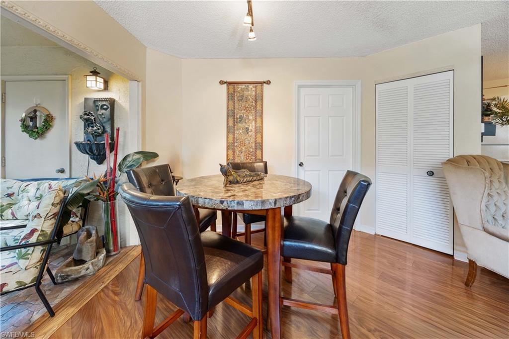 Dining space with a textured ceiling and wood-type flooring