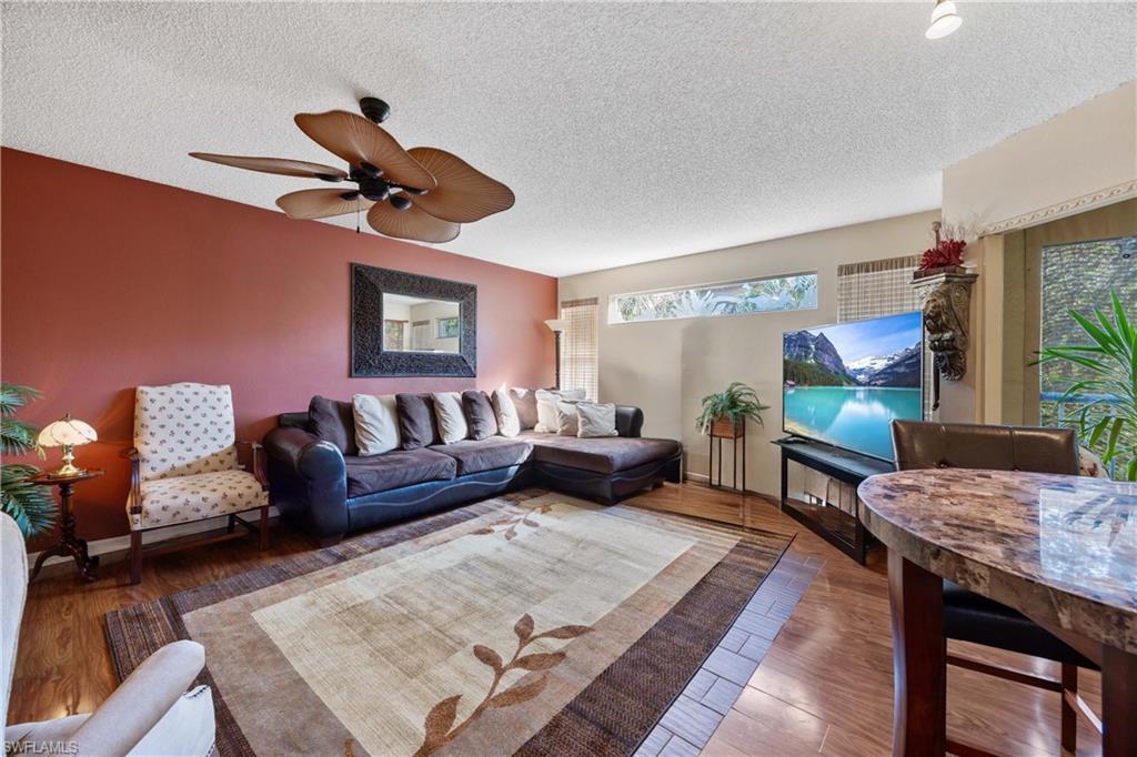 Living room featuring hardwood / wood-style floors, a textured ceiling, and ceiling fan