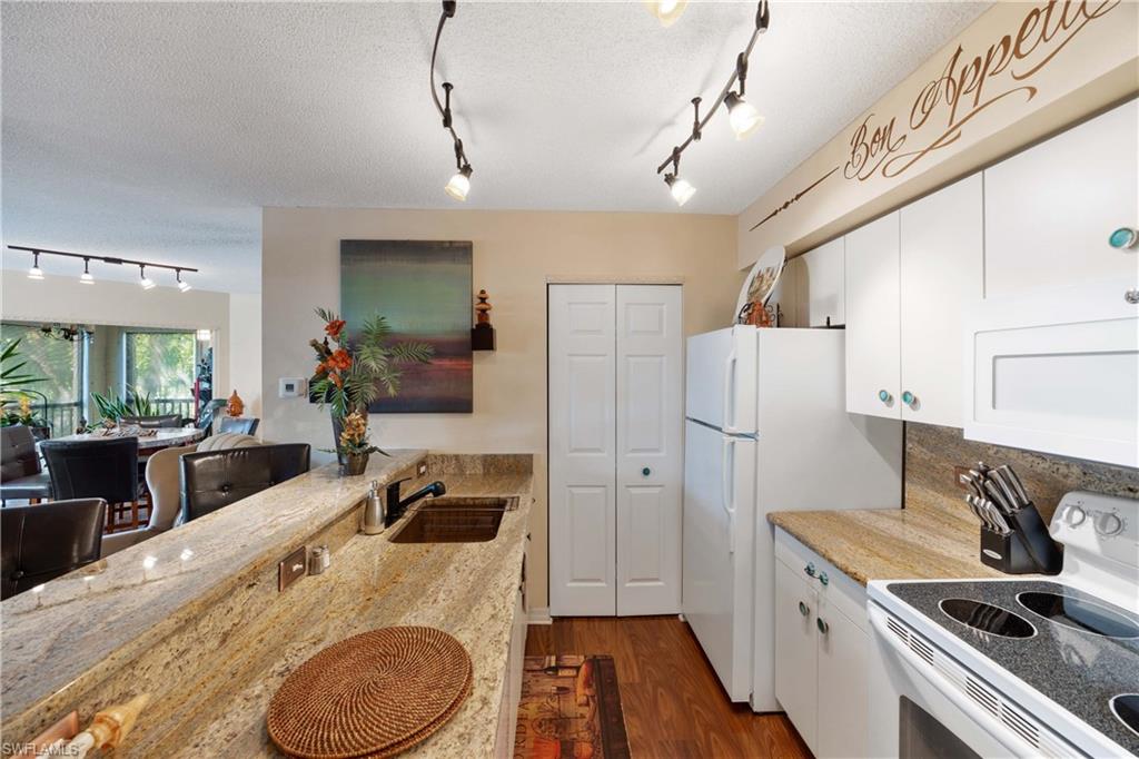 Kitchen featuring sink, white cabinets, white appliances, and dark hardwood / wood-style flooring