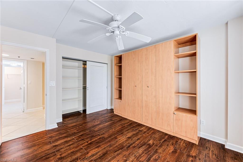 Unfurnished bedroom with a closet, ceiling fan, and dark hardwood / wood-style flooring