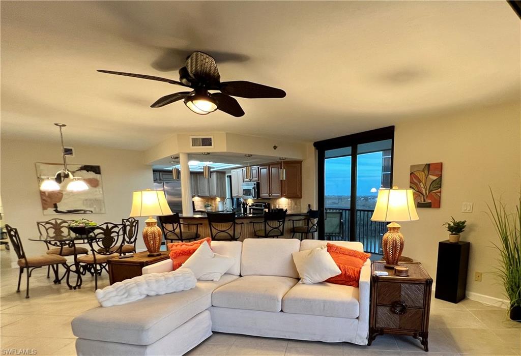 Living room featuring ceiling fan with notable chandelier