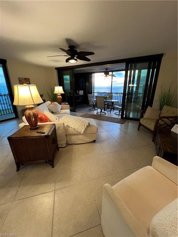 Tiled living room with ceiling fan and expansive windows