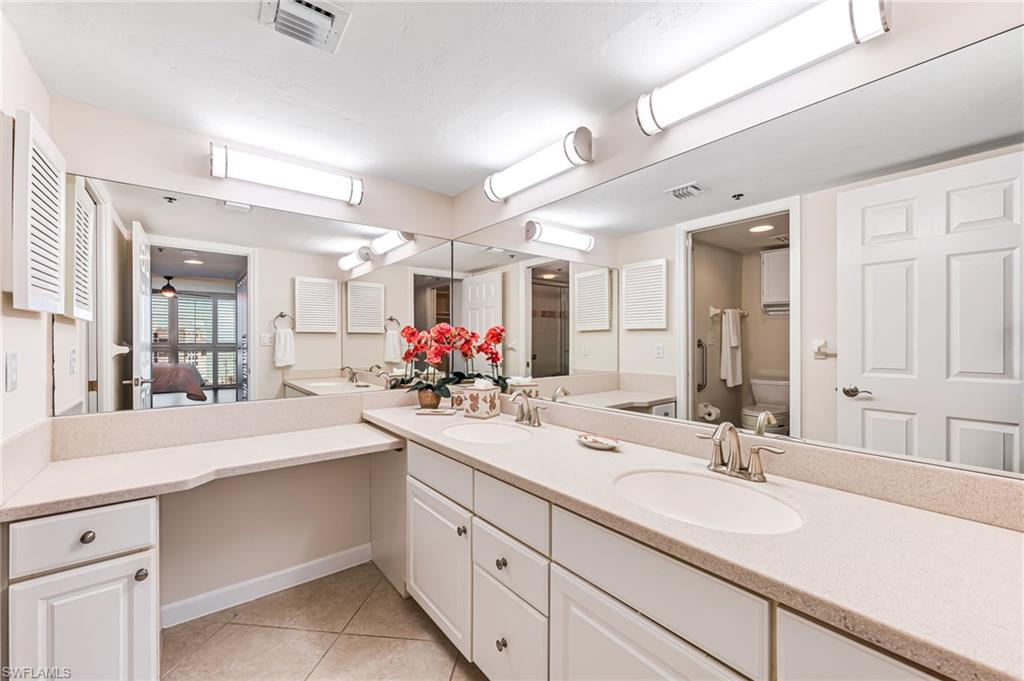 Bathroom with toilet, vanity, and tile patterned floors