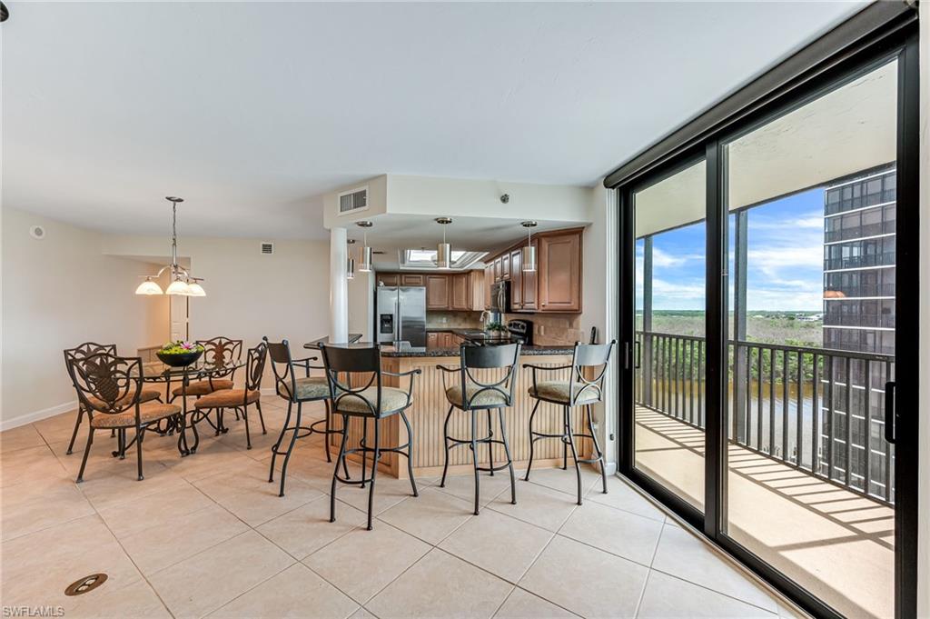 Kitchen featuring light tile patterned floors, stainless steel fridge with ice dispenser, and kitchen peninsula