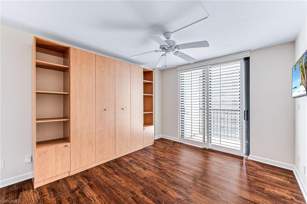 Unfurnished bedroom with dark hardwood / wood-style floors and ceiling fan