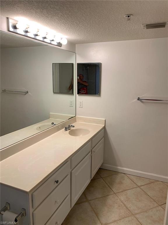Bathroom featuring vanity, a textured ceiling, and tile patterned floors