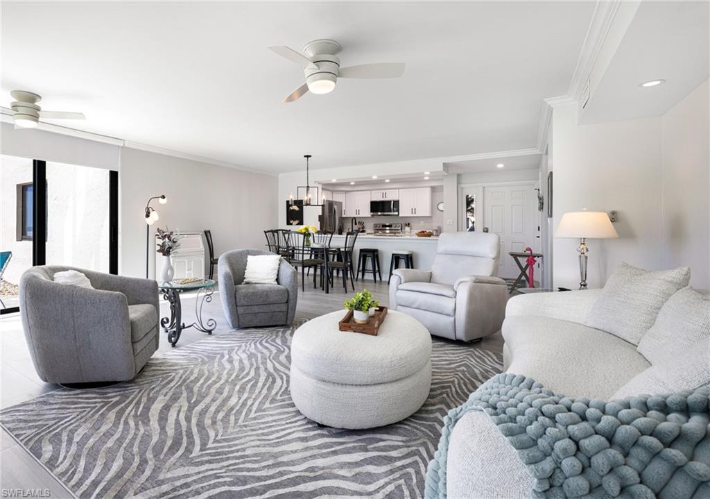 Living room with ornamental molding and ceiling fan