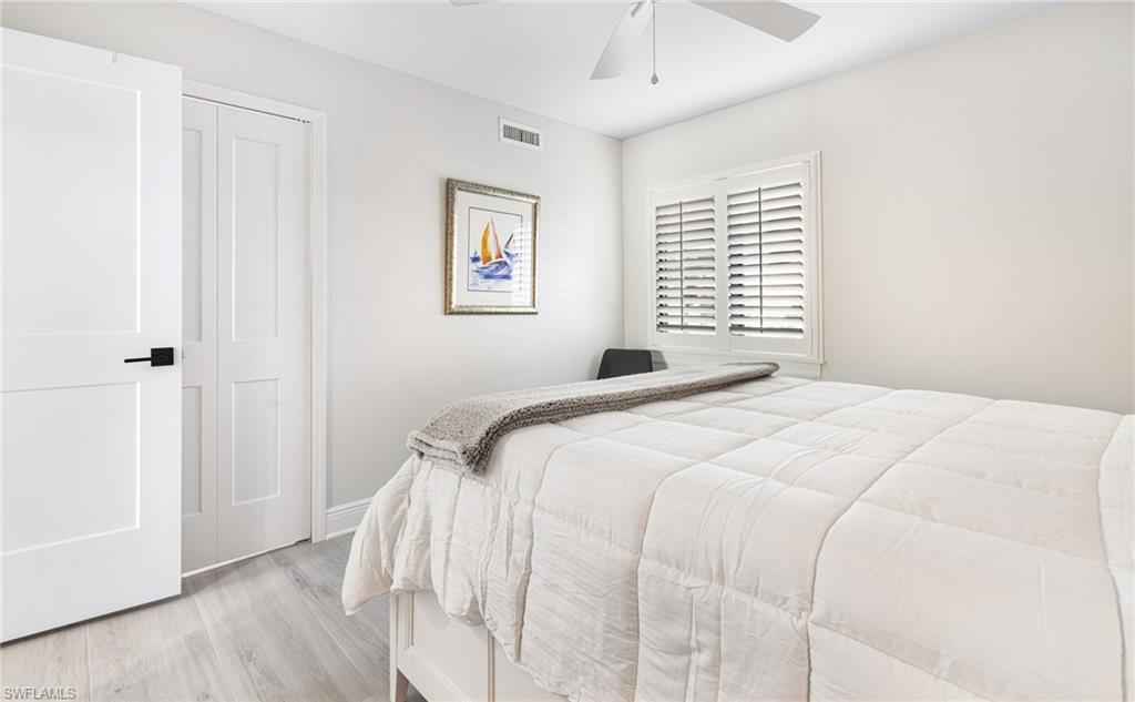 Bedroom with light hardwood / wood-style flooring, a closet, and ceiling fan