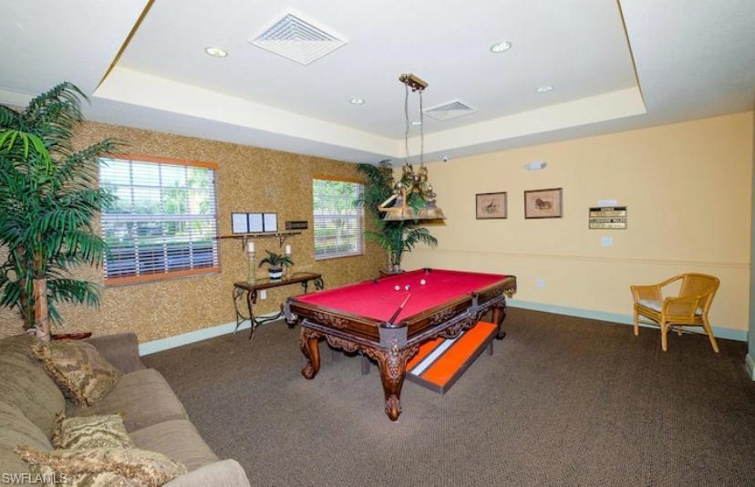 Rec room with dark colored carpet, billiards, and a raised ceiling
