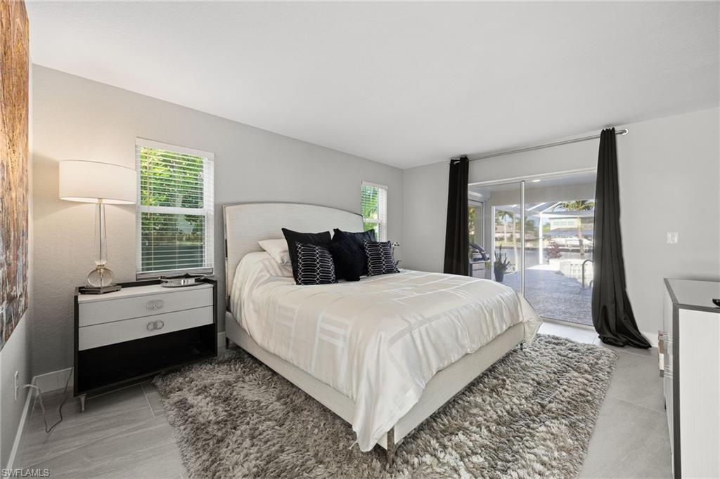 Sliding glass doors opening to outdoor space, overhead lighting, window with blinds, light-toned wall paint, tile flooring