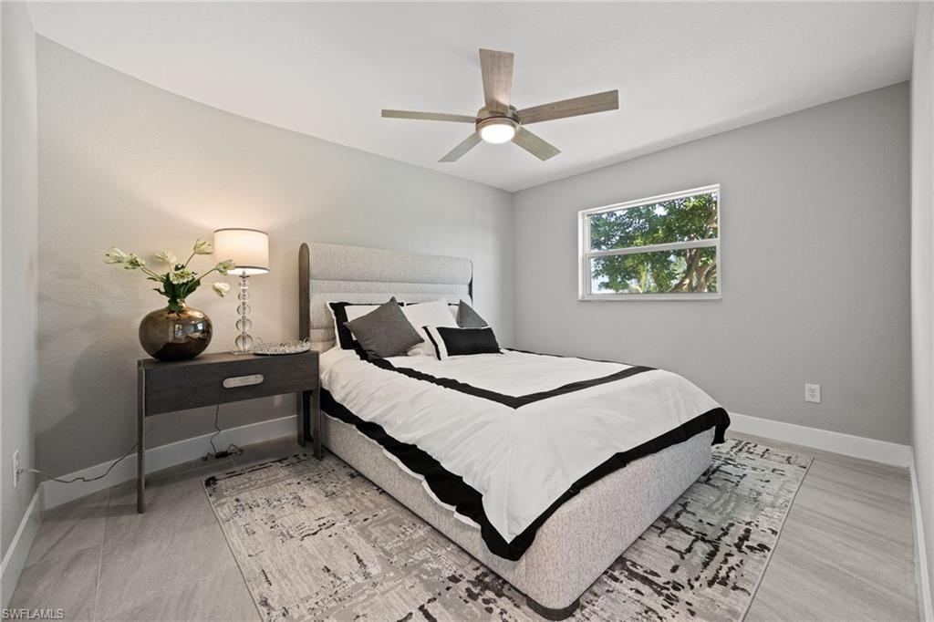 Recessed lighting, ceiling fan with integrated lighting, window with exterior scenery, light gray wall finish, and light-toned tile flooring