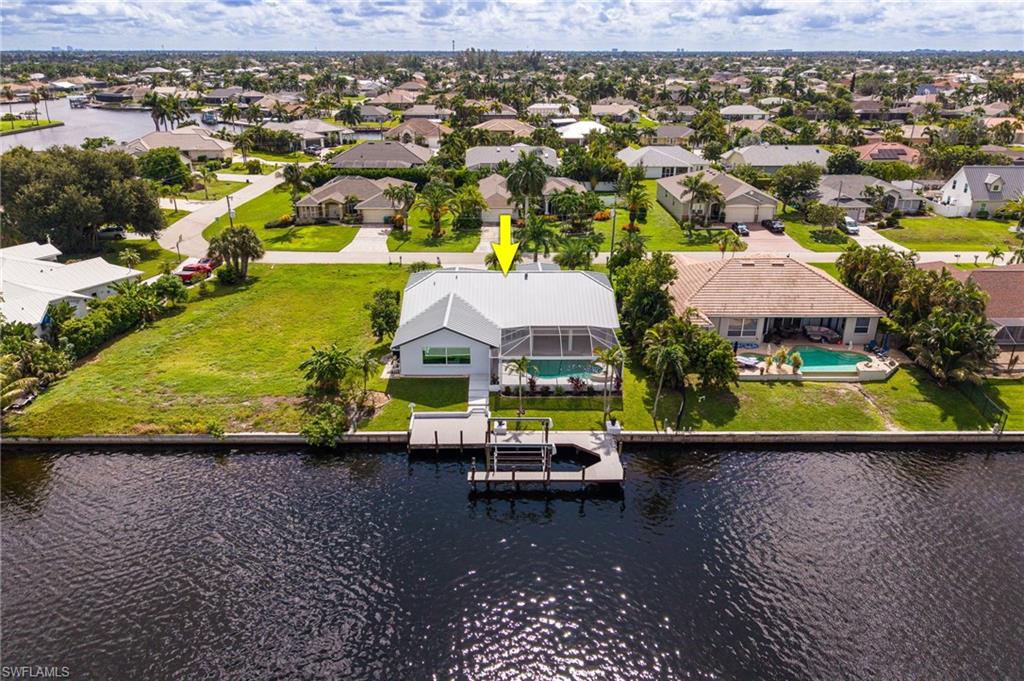Waterfront property featuring a screened-in pool, private boat dock, and a metal roof