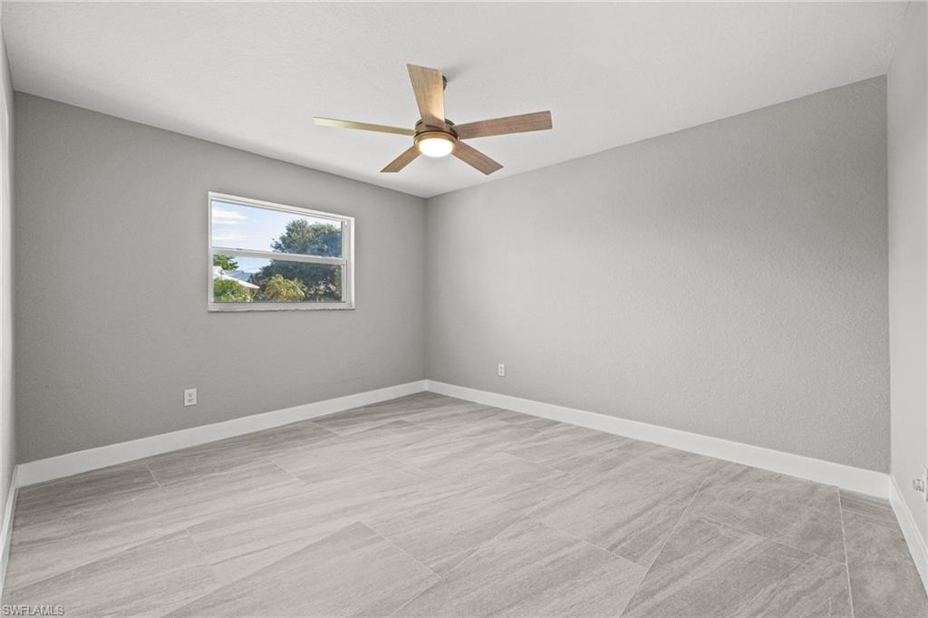 Recessed window with exterior scenery, contemporary ceiling fan, and wood-finish tile flooring