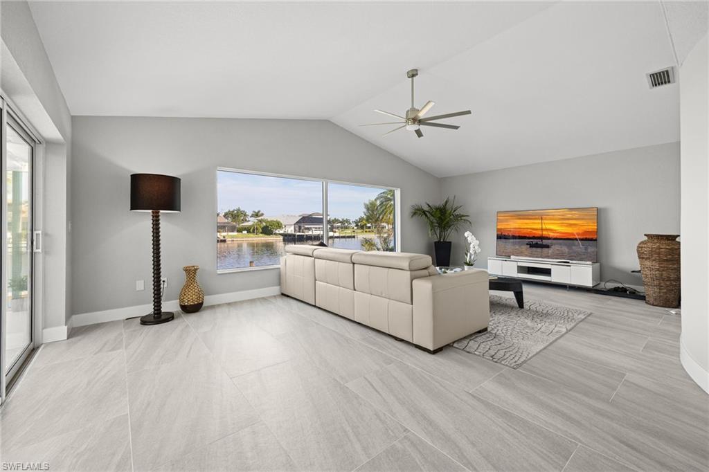 Vaulted ceiling, ceiling fan, large sliding glass door, expansive window, large format tile flooring