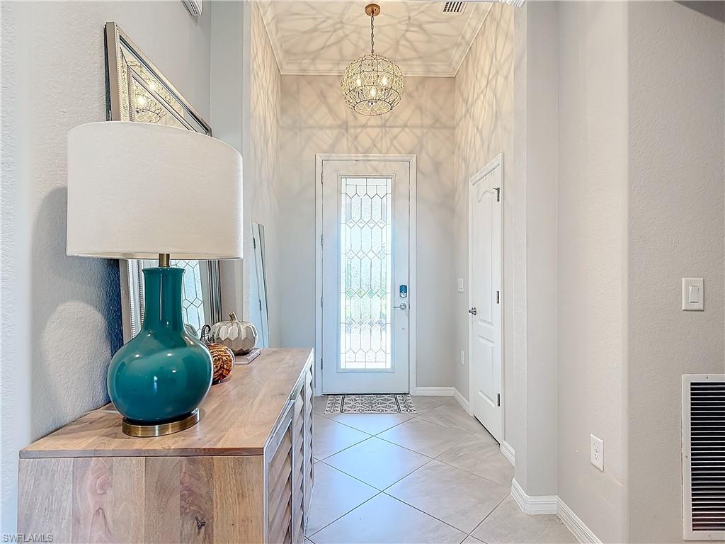 Entrance foyer with a notable chandelier and light tile patterned floors