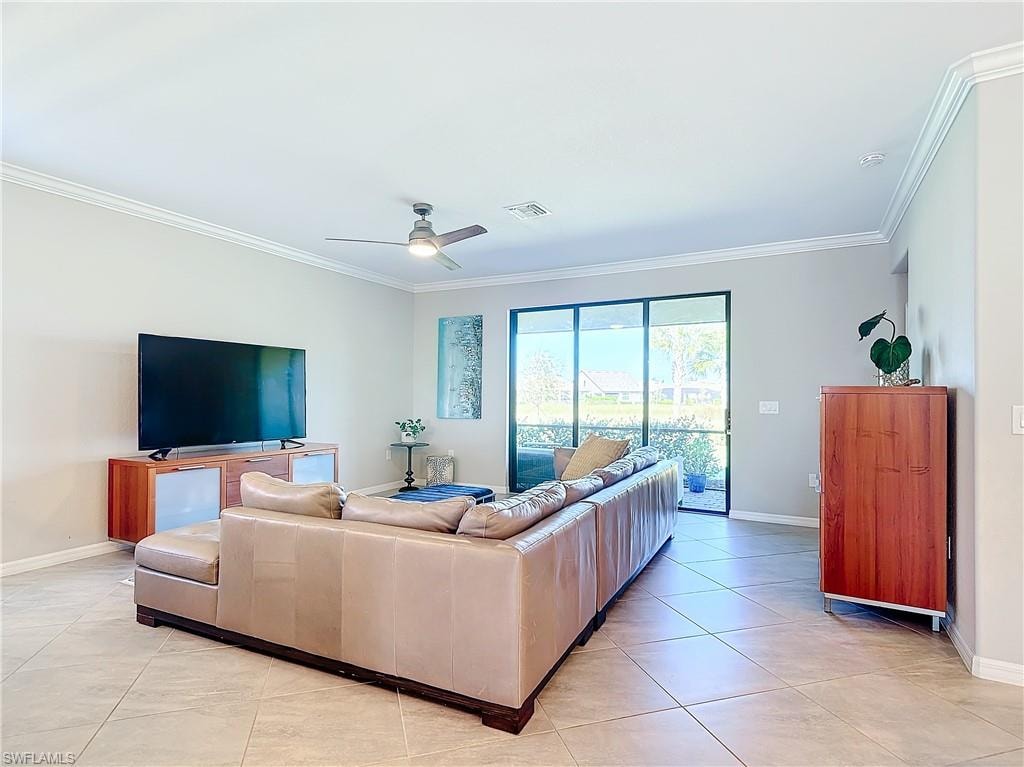 Tiled living room with ornamental molding and ceiling fan