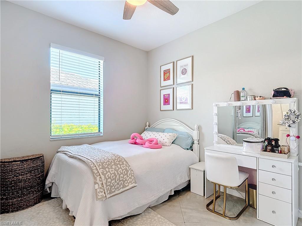 Tiled bedroom featuring ceiling fan