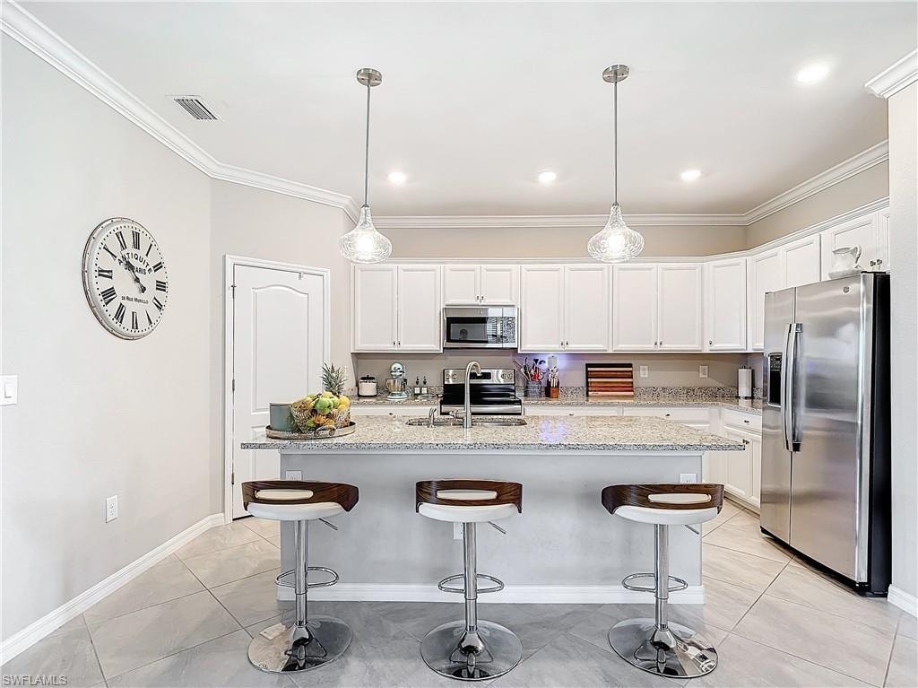Kitchen with white cabinetry, hanging light fixtures, sink, and stainless steel appliances