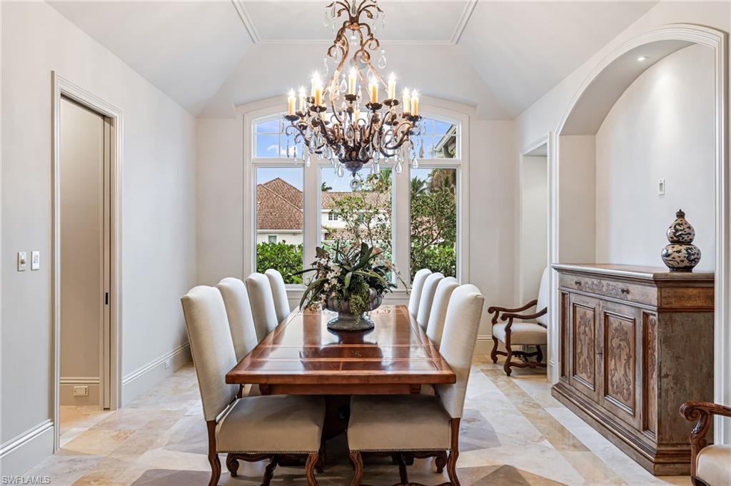 Dining space featuring vaulted ceiling, an inviting chandelier, and ornamental molding