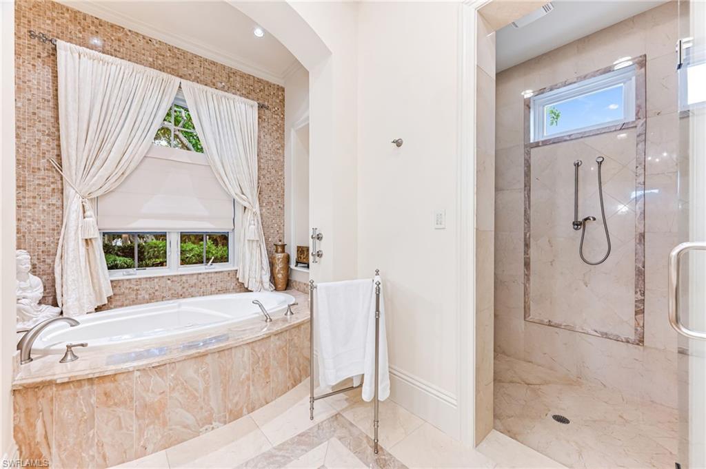 Bathroom featuring separate shower and tub, ornamental molding, and a wealth of natural light